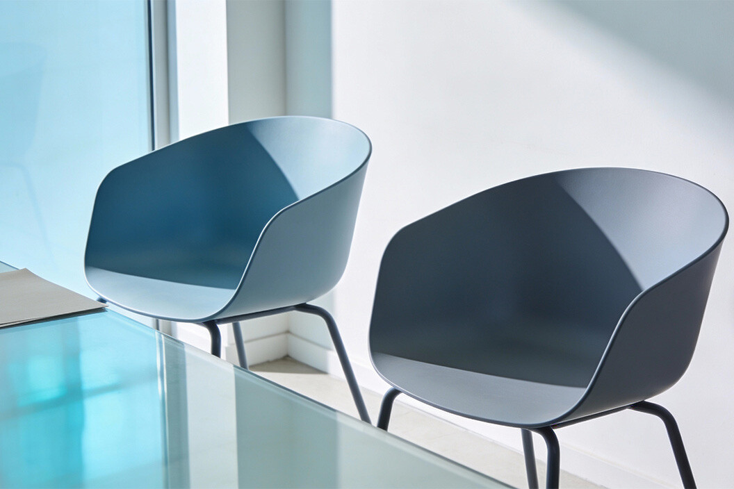 Eine helle Büro zu sehen sind 2 blaue stuhle und eine Glastisch auf dem Tisch sind Unterlagen